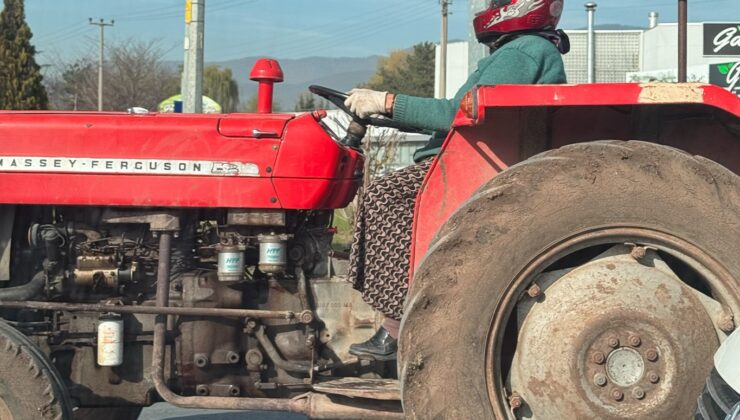 Motosiklet kaskıyla traktör kullanan kadın